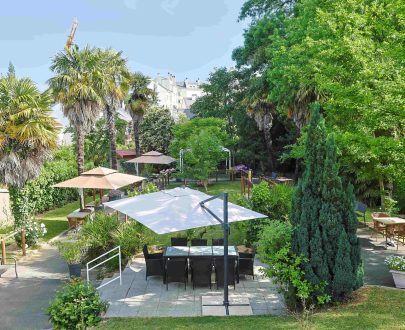 Jardin avec plantes, arbres, tables, parcours de marche,